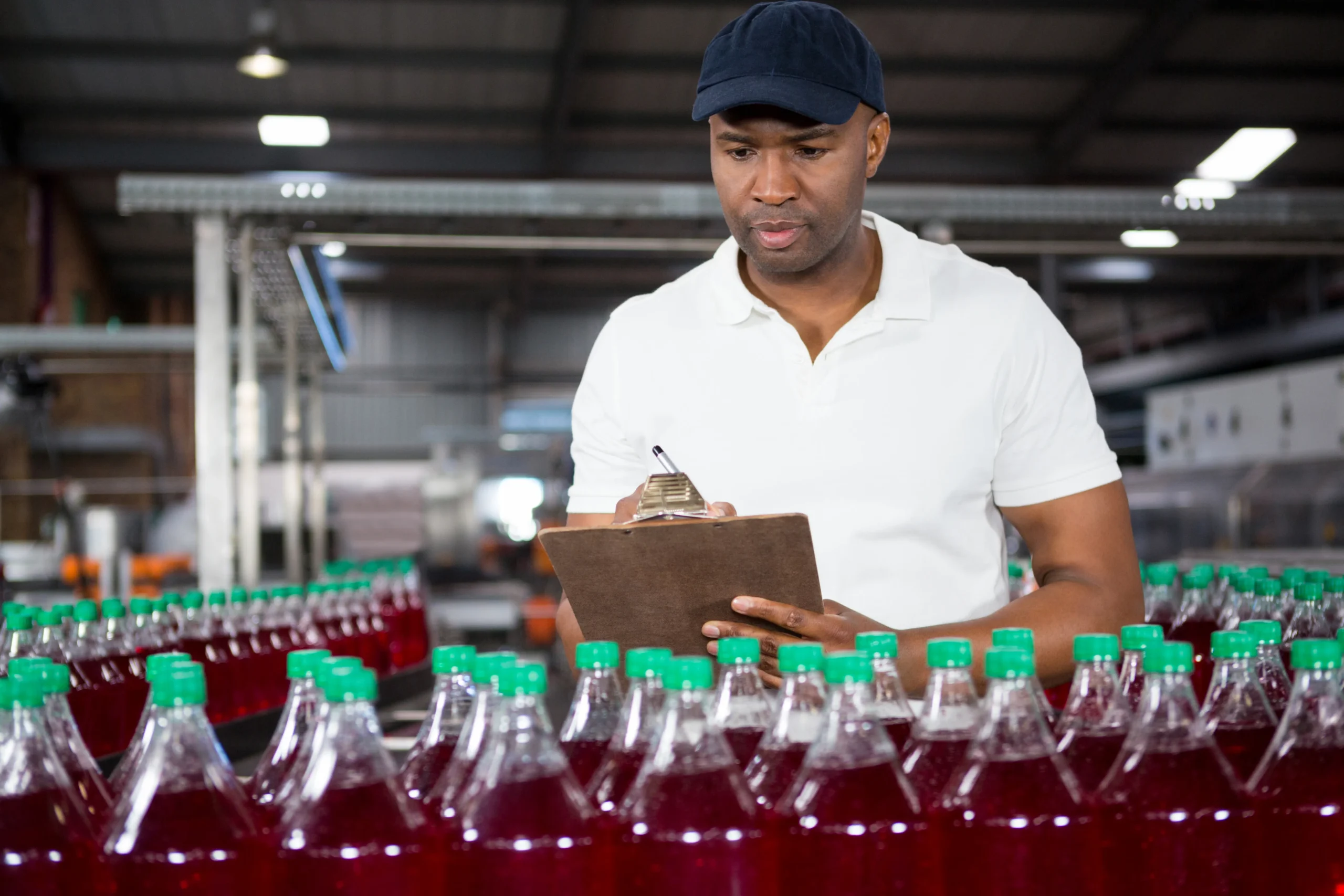 male-worker-writing-clipboard-factory - Incture Technologies Supervising Bottlers